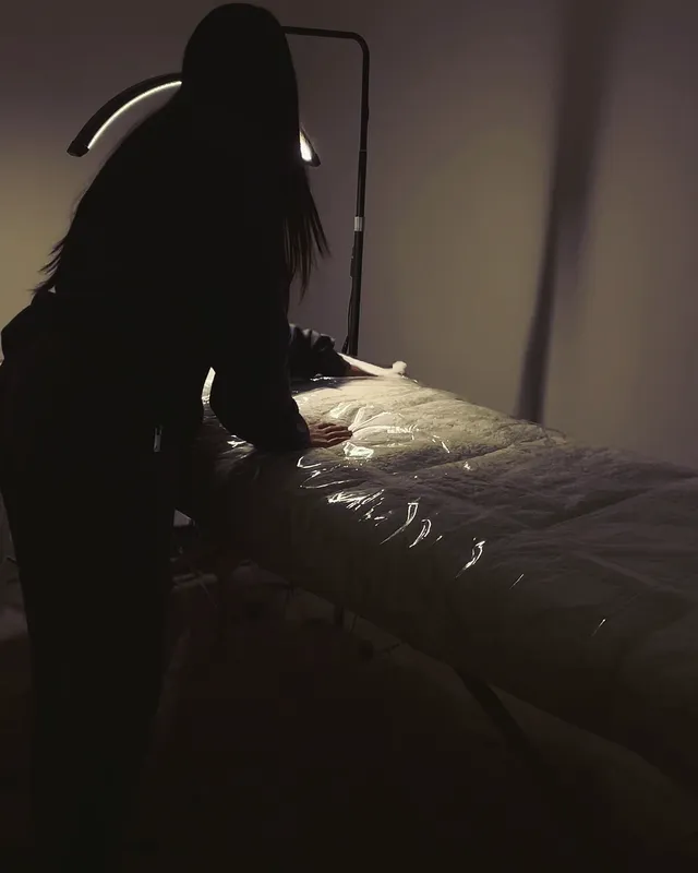 Sahej setting up her lash bed under the lash lamp before a client